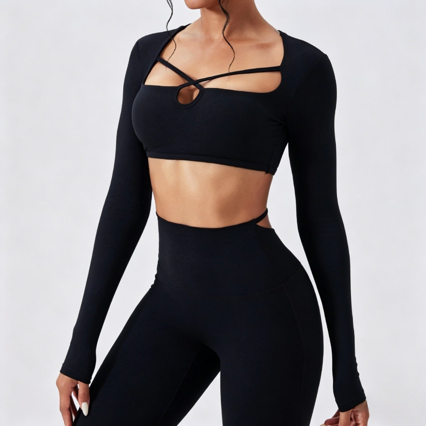 Women’s black long sleeve cutout crop top with matching high waist leggings in seamless stretchy activewear fabric