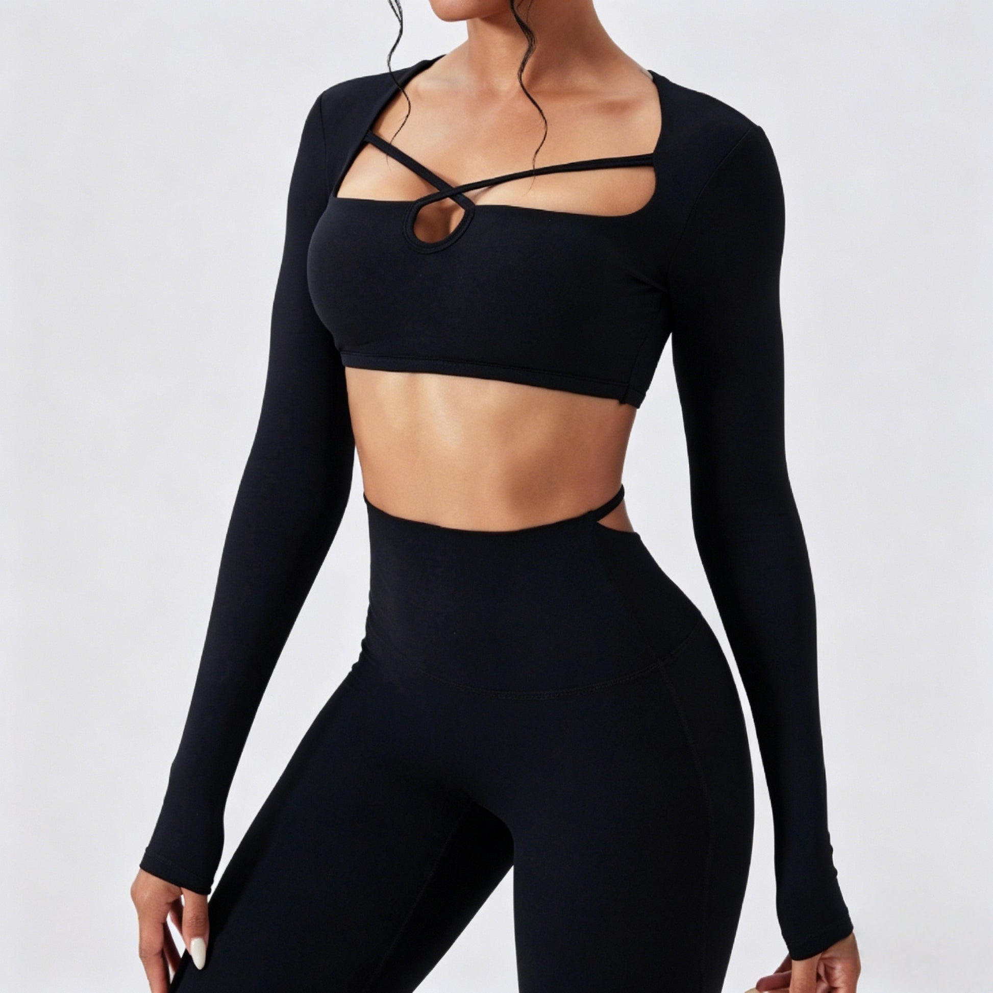 Women’s black long sleeve cutout crop top with matching high waist leggings in seamless stretchy activewear fabric